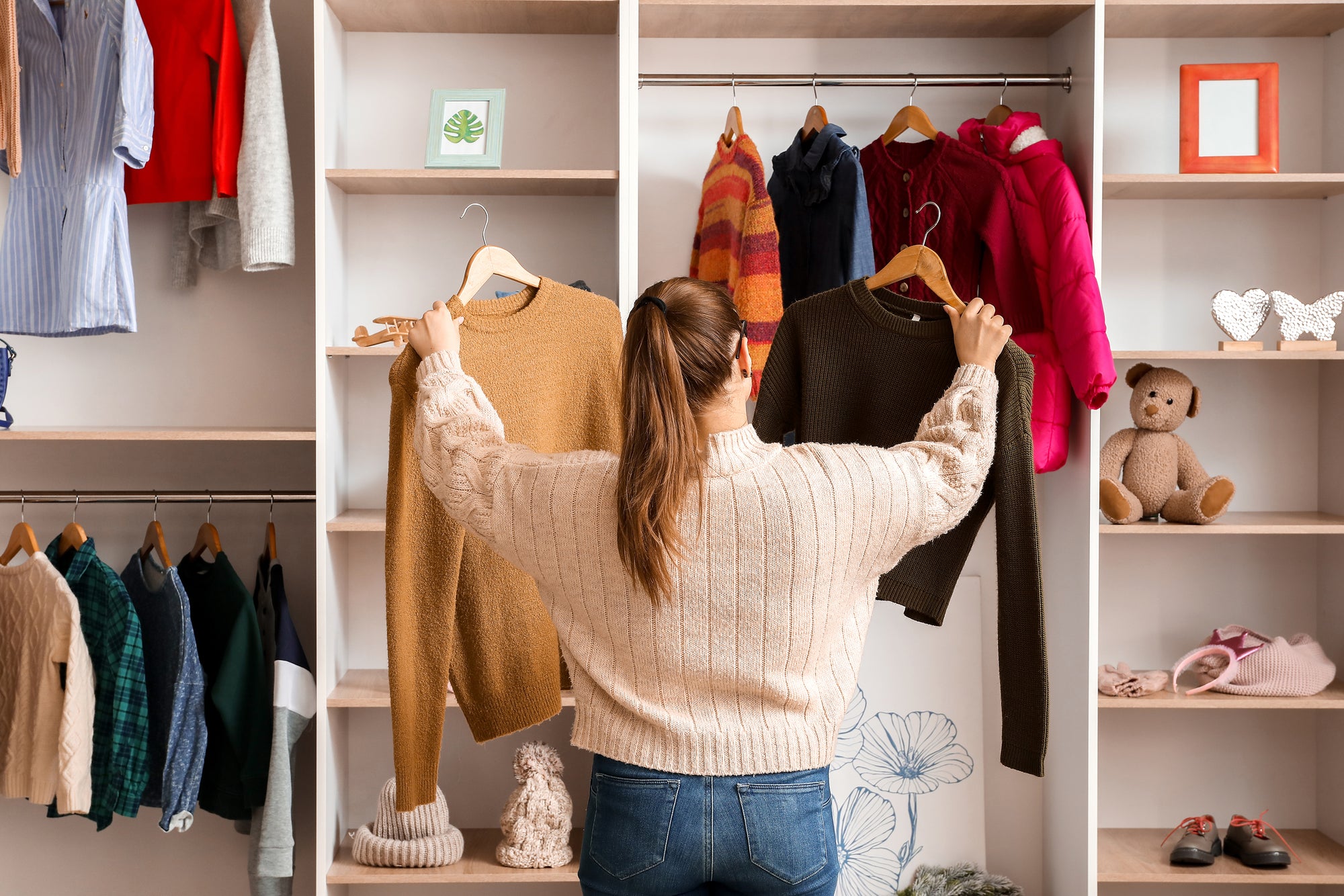 woman looking at winter clothes in wardrobe