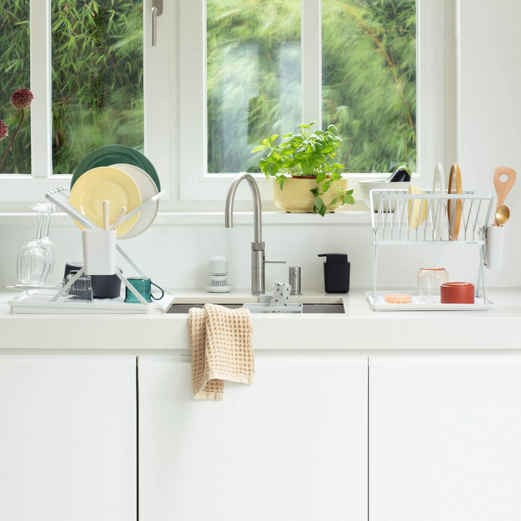 Two rust-proof Brabantia dish racks next to a stainless steel kitchen sink