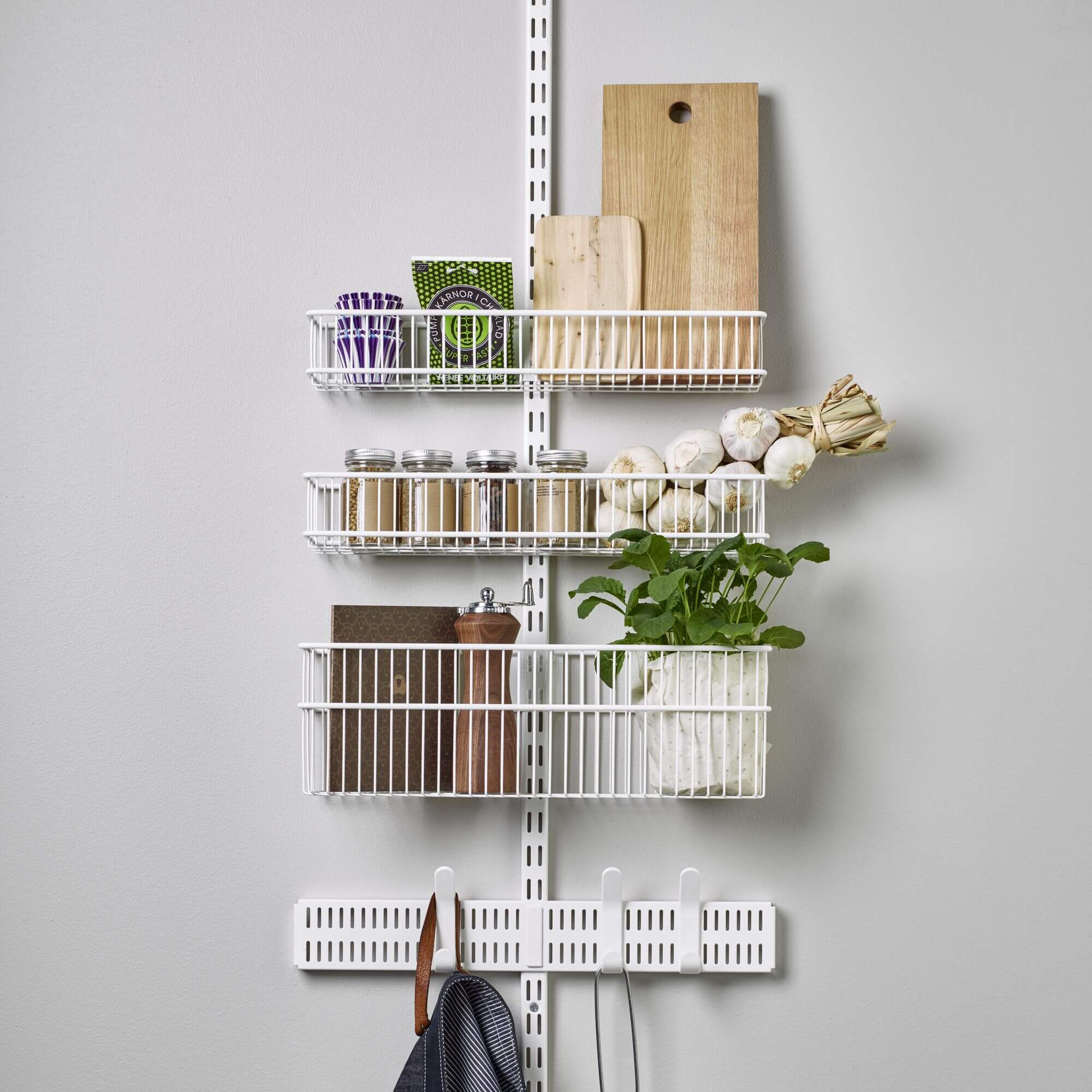 Kitchen containers, spice jars and cutting boards stored in an Elfa Utility Over the Door Storage system