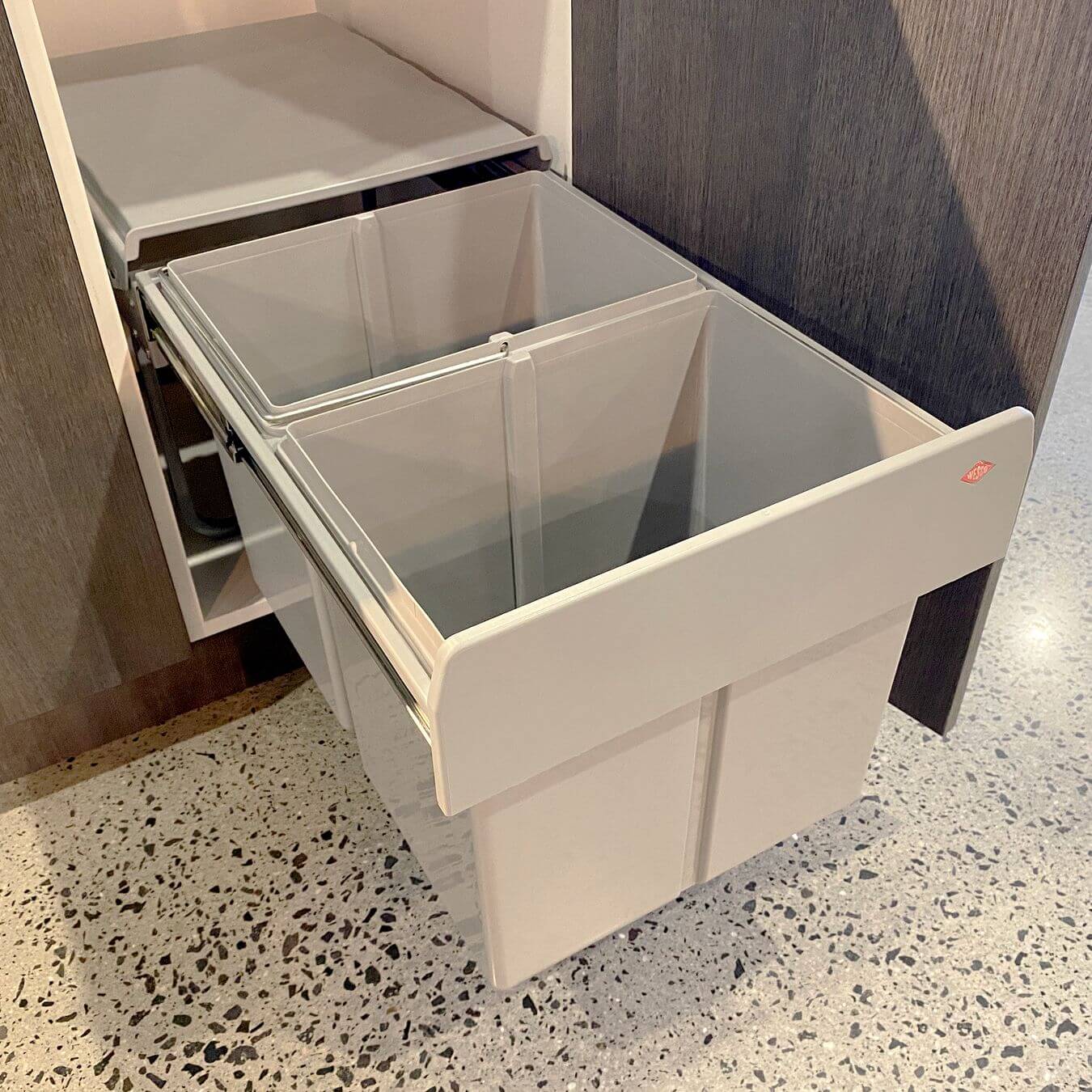 A grey Wesco Built In Bin installed in a kitchen cupboard