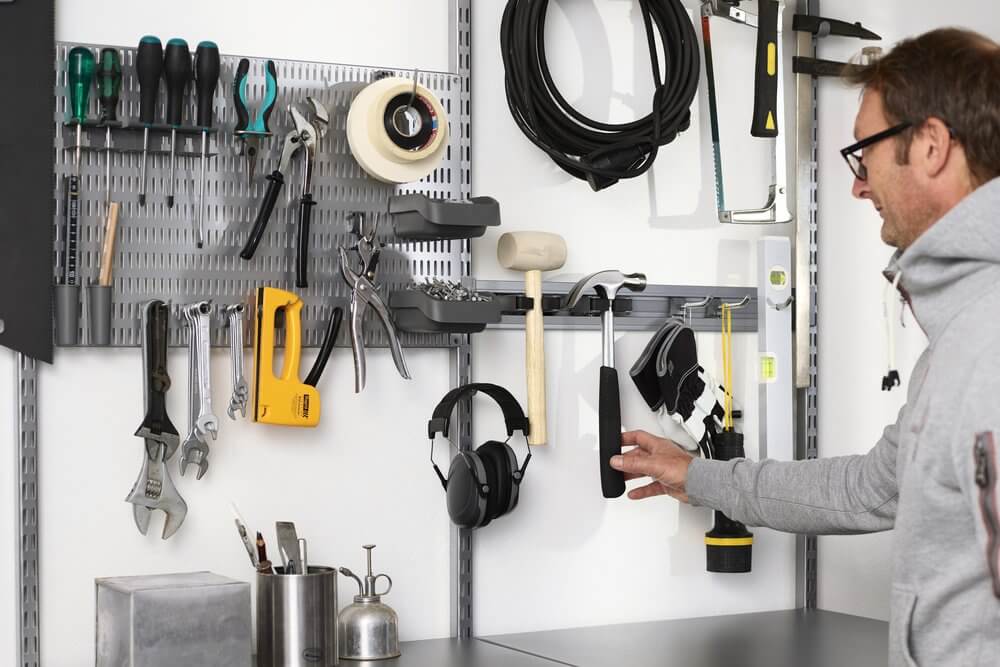 An Elfa Storing Board and Storage Track used in a garage to organise screwdrivers, spanners and other tools